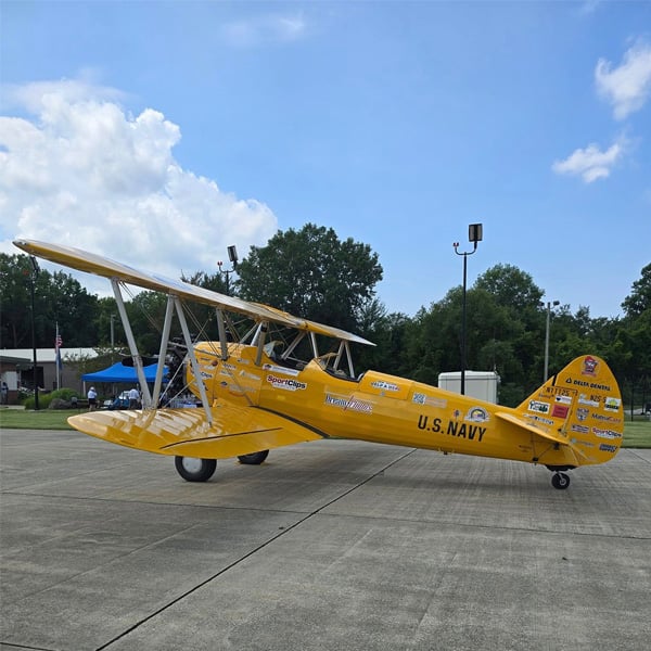 Vintage yellow U.S. Navy biplane parked on the tarmac at Michigan City Municipal Airport